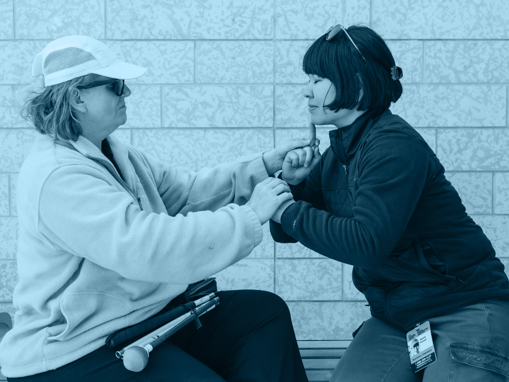 A staff uses tactile ASL with a client.